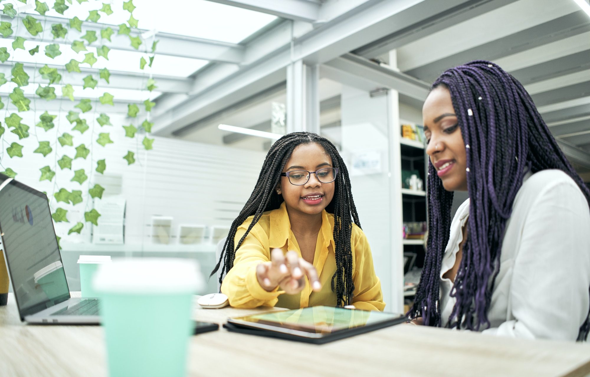 Two business girls using a tablet in the office.